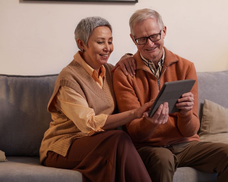 Two people on a sofa reading something together on a tablet